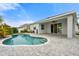 Backyard pool surrounded by a paved patio, featuring a covered porch, and tropical landscaping at 559 Spotted Slipper Pl, Ruskin, FL 33570