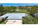 View of the home's roof and the adjacent golf course with mature trees and a water feature at 5621 Palm Aire Dr, Sarasota, FL 34243