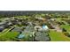 An aerial view of the tennis and pickleball courts along with golf course and clubhouse at 5621 Palm Aire Dr, Sarasota, FL 34243