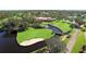Aerial view of the golf course, water features, and the clubhouse at 5621 Palm Aire Dr, Sarasota, FL 34243