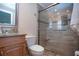 Bathroom with glass enclosed shower, wood vanity and granite countertop at 5621 Palm Aire Dr, Sarasota, FL 34243