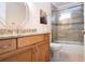 Bathroom with a tiled shower, granite countertops, and wood cabinets at 5621 Palm Aire Dr, Sarasota, FL 34243