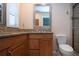 Bathroom featuring granite countertops, wood cabinets, and tiled shower at 5621 Palm Aire Dr, Sarasota, FL 34243