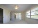 Bedroom with a ceiling fan, windows with outdoor view, and access to additional rooms via doorways and sliding doors at 5621 Palm Aire Dr, Sarasota, FL 34243