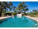 Sparkling community pool featuring lounge chairs and lush landscaping on a sunny day at 5621 Palm Aire Dr, Sarasota, FL 34243