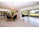 Light-filled dining area with backyard view, wood table, and black velvet chairs at 5621 Palm Aire Dr, Sarasota, FL 34243