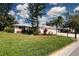 This lovely home boasts a well-manicured lawn and colorful landscaping, with a two-car garage at 5621 Palm Aire Dr, Sarasota, FL 34243