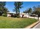 Well-maintained single-story home with a lush lawn and colorful landscaping at 5621 Palm Aire Dr, Sarasota, FL 34243