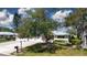 Well-maintained home with mature trees, lush landscaping, and a spacious driveway at 5621 Palm Aire Dr, Sarasota, FL 34243