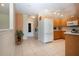 Functional kitchen with white appliances, wooden cabinets and laundry area nearby at 5621 Palm Aire Dr, Sarasota, FL 34243