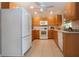 Bright kitchen with white appliances, wooden cabinets, and neutral backsplash tiles at 5621 Palm Aire Dr, Sarasota, FL 34243