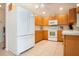 Kitchen with white appliances and wooden cabinets at 5621 Palm Aire Dr, Sarasota, FL 34243