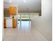 Bright kitchen with tiled floor, wood cabinetry, and an adjoining living space with expansive windows overlooking the yard at 5621 Palm Aire Dr, Sarasota, FL 34243