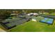 Areal view of a tennis and pickleball complex in a community with lush landscaping at 5621 Palm Aire Dr, Sarasota, FL 34243