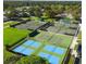 Overhead image displaying the tennis and pickleball courts with lush landscaping at 5621 Palm Aire Dr, Sarasota, FL 34243