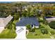 Aerial view of a home showing the manicured lawn, screened-in pool, landscaping, and driveway at 5646 Country Lakes Dr, Sarasota, FL 34243