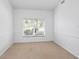 Bright and airy bedroom with neutral carpet, a chair rail, and a large window with blinds at 5646 Country Lakes Dr, Sarasota, FL 34243