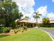 Beautiful exterior view with tropical landscaping and a covered entrance at 5646 Country Lakes Dr, Sarasota, FL 34243