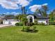 Beautiful one-story home featuring an arched entryway, lush front lawn, and a two car garage at 5646 Country Lakes Dr, Sarasota, FL 34243