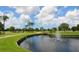 Scenic golf course view features lush green grass, mature trees, a water feature and a fountain on a sunny day at 5646 Country Lakes Dr, Sarasota, FL 34243