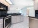 Open kitchen layout featuring stainless steel appliances, tile flooring, and a breakfast bar overlooking the living area at 5646 Country Lakes Dr, Sarasota, FL 34243