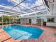 Inviting swimming pool, screen enclosed for privacy, next to an outdoor bar and patio area at 5646 Country Lakes Dr, Sarasota, FL 34243