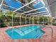 Inviting in-ground pool with screened enclosure, complemented by well-maintained brickwork and tropical scenery at 5646 Country Lakes Dr, Sarasota, FL 34243