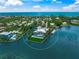 Aerial view of coastal community showcases stunning waterfront home with lush landscaping, boat dock, and pool at 612 Juan Anasco Dr, Longboat Key, FL 34228