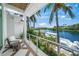 Cozy balcony with water views, patio furniture, and lush tropical landscaping at 612 Juan Anasco Dr, Longboat Key, FL 34228