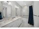 This bathroom features double sinks, a shower-tub combo, and white brick-style walls at 612 Juan Anasco Dr, Longboat Key, FL 34228