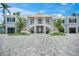 Elegant home featuring an impressive entrance with dual staircases and an expansive paved driveway at 612 Juan Anasco Dr, Longboat Key, FL 34228