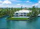 Stunning waterfront home with a modern design, lush landscaping, and a beautiful pool overlooking the water at 612 Juan Anasco Dr, Longboat Key, FL 34228