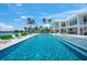 Resort-style swimming pool with sun loungers, volleyball net, and picturesque waterfront views, perfect for outdoor recreation at 612 Juan Anasco Dr, Longboat Key, FL 34228