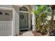 Welcoming entryway featuring a green door with wreath, a decorative sidelight and a lush tropical landscape at 6226 Blueflower Ct, Lakewood Ranch, FL 34202