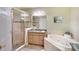 Elegant bathroom featuring a glass-enclosed shower, soaking tub, and a granite countertop vanity with double sinks at 6512 Moorings Point Cir # 201, Lakewood Ranch, FL 34202