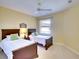 Cozy bedroom with two twin beds, soft carpet, and a ceiling fan, perfect for guests or children at 6512 Moorings Point Cir # 201, Lakewood Ranch, FL 34202