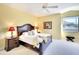 Comfortable bedroom with a plush bed, soft carpet, and a ceiling fan offering a relaxing retreat at 6512 Moorings Point Cir # 201, Lakewood Ranch, FL 34202