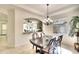 Elegant dining room features a chandelier, stylish table with six chairs, and views into kitchen area at 6512 Moorings Point Cir # 201, Lakewood Ranch, FL 34202