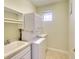Efficient laundry area includes stacked washer and dryer unit, built-in sink and cabinets, and a sunny window at 6512 Moorings Point Cir # 201, Lakewood Ranch, FL 34202