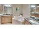 The main bathroom features double sinks, granite counters, and a large soaking tub at 6512 Moorings Point Cir # 201, Lakewood Ranch, FL 34202
