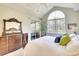 Bright main bedroom features a mirrored dresser, and sliding glass doors to a screened balcony at 6512 Moorings Point Cir # 201, Lakewood Ranch, FL 34202