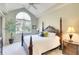 Bright main bedroom with a four poster bed, vaulted ceilings, large window, and neutral decor at 6512 Moorings Point Cir # 201, Lakewood Ranch, FL 34202
