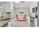 Bright kitchen featuring white cabinetry, stainless steel appliances, and a cozy breakfast nook at 6732 Keystone Dr, Sarasota, FL 34231