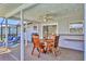 Covered patio featuring wooden table and chairs with BBQ grill and lounge chairs in the background at 6732 Keystone Dr, Sarasota, FL 34231
