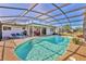 A covered pool area featuring an in-ground pool, patio, grill, and lounge chairs at 6732 Keystone Dr, Sarasota, FL 34231