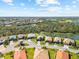 Aerial view of a residential neighborhood showcasing manicured lawns, a serene pond, and lush landscaping at 6912 Gosport Cv, Bradenton, FL 34202
