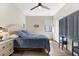 Bedroom features wood-look floors, neutral walls, a ceiling fan, and a blue comforter at 6912 Gosport Cv, Bradenton, FL 34202