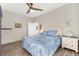 Comfortable bedroom featuring wood-look floors, neutral walls, and a white headboard with blue pillows at 6912 Gosport Cv, Bradenton, FL 34202