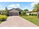 Charming single-Gathering home displaying a two-car garage, brick driveway, and landscaped front yard at 6912 Gosport Cv, Bradenton, FL 34202