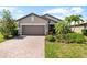 Charming single-Gathering home displaying a two-car garage, brick driveway, and landscaped front yard at 6912 Gosport Cv, Bradenton, FL 34202